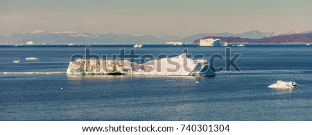 Panoramic view of Disko Bay with icebergs from the village Oqaatsut in the summer night. Their source is the Eqip Sermia Glacier, West Greenland 
