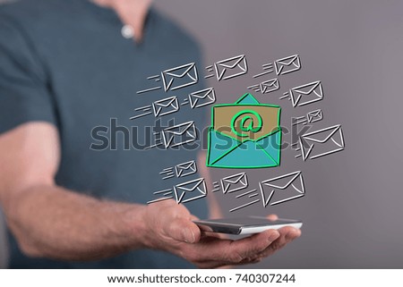 Email concept above a smartphone held by a man in background