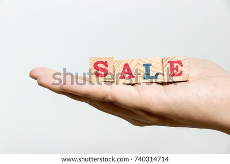 Man hold wood block with wording sale on concrete background