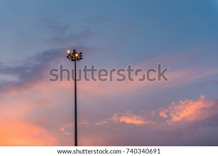 street light, electric spotlight pole with sunset as background