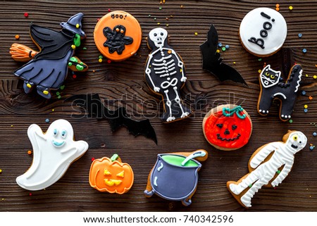 Cook halloween gingerbread cookies with witch, skeleton, ghost. wooden background top view
