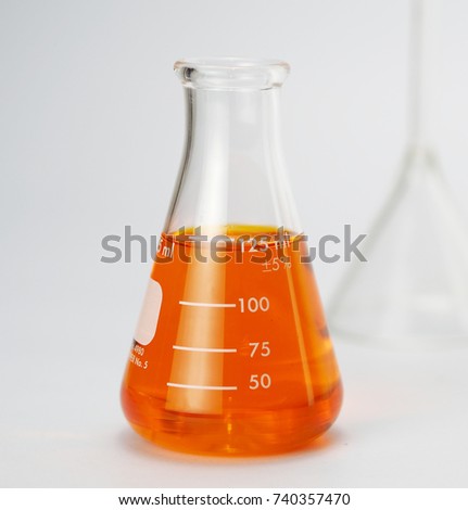 Laboratory Erlenmeyer Flask with liquids of orange color on white background