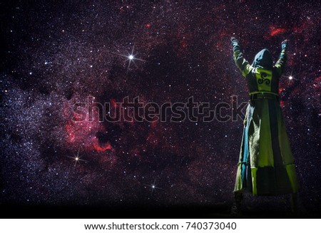 a mystical person stands in the night before the starry sky