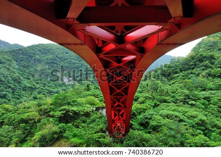 Looking at the red arch bridge across the forest, it is the aesthetics of the construction of the project. Taiwan, Asia.
