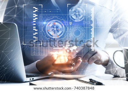 Close up of female hands using cellphone with glowing business projection at workplace with laptop, coffee cup and paperwork. Analytics concept. Double exposure 