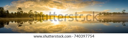 Panoramic view of sunrise over the lake in nation park, Beautiful rainforest landscape with fog in morning, Thailand  Royalty-Free Stock Photo #740397754