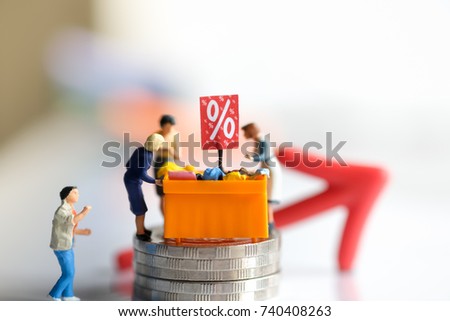 Miniature people: Shoppers with discount tray for shopping discounted items using as background business concept.