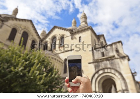 Tourist hands holding smart phone taking photo of Perigueux, France