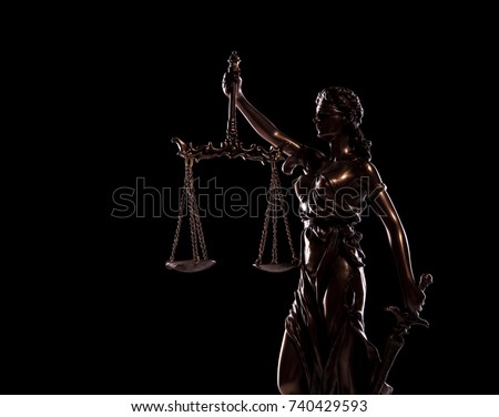 side view picture of goddess of justice statue on black background