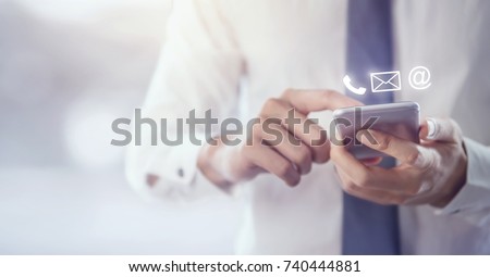 CONTACT US, Hand of Businessman holding mobile smartphone with ( mail,phone,email ) icon. cutomer support concept, copy space. Royalty-Free Stock Photo #740444881