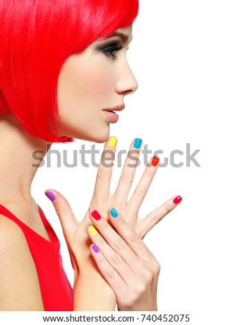 Closeup face of a beautiful  girl with bright multicolor nails. Profile portrait of a Gorgeous and stunning  woman with bob hairstyle red color. 