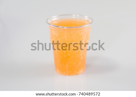 orange soda juice in plastic glass and white background