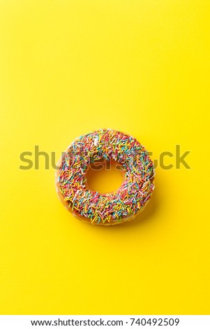 Donut on yellow background. Top view. Copy space.