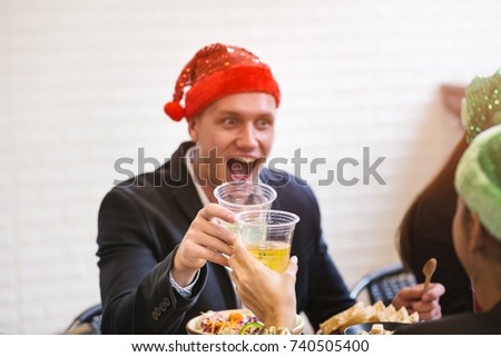 close up of Happy businessman with Colleague in the office 'cheer"drinking in santa hat at Xmas party.