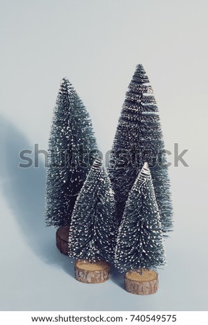 Vintage photography filtered of Isolated group of full artificial firs like a small forest tree on a blue pastel background. Minimal still life photography 