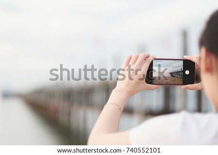 Hands of woman using a smart phone for take a picture with blured background.