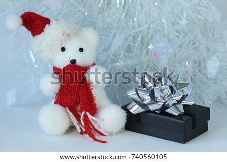 polar bear wearing a hat and a red scarf posed next to gifts with shiny knots on a Christmas holiday decor