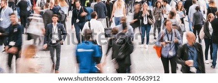 Crowd of anonymous people walking in a hall