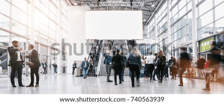 anonymous blurred people rushing at a trade fair 