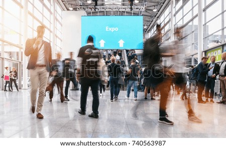 anonymous blurred people rushing at a expo