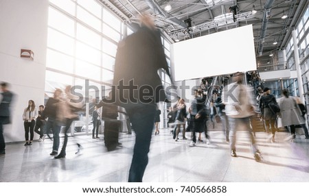 Anonymous blurred business people walking in a hall of a Exhibition