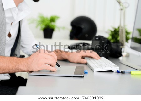 hands detail close-up of male photographer editing photography with a computer and graphic tablet
