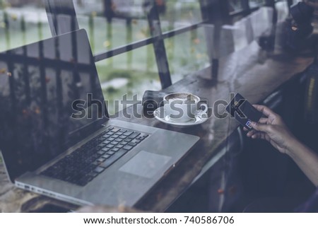 Young businessman using tablet computer in classy coffee shop.Interior of coffee shop with customer using digital devices on free wifi internet service.
