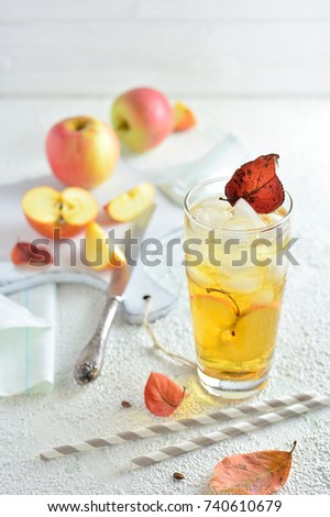 Apple in a glass of juice with ice, still life with apples on a light background