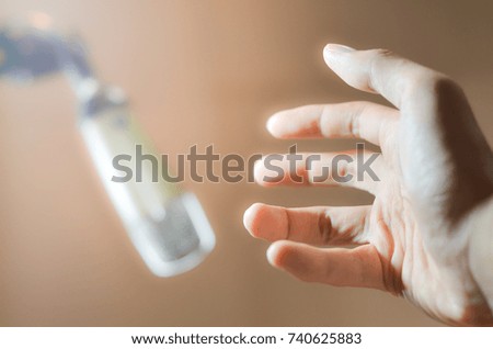 men hand holding a single retro microphone against brown background,select focus