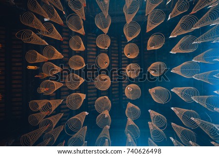 Royalty high quality free stock image of circle incense is hanging high on roof and burning. It praying lucky and happy for people buying. Close focus of incense with copy space for text advertising