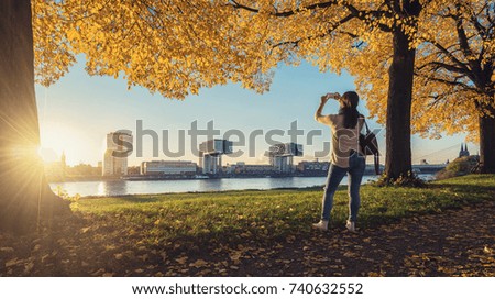 Woman takes a picture from the Skyline of Cologne at autumn