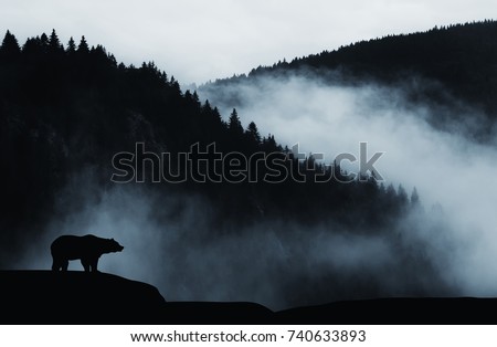 minimal wilderness landscape with bear silhouette and misty mountains Royalty-Free Stock Photo #740633893