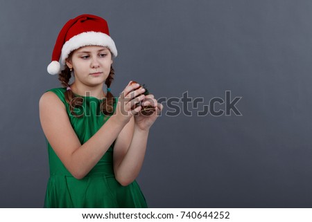 Portrait of little girl in santa hat on grey background