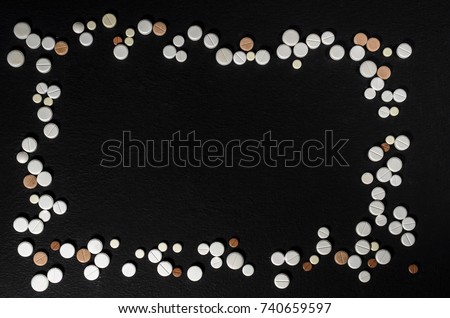 Frame of pills on a dark background with free space for text, top view
