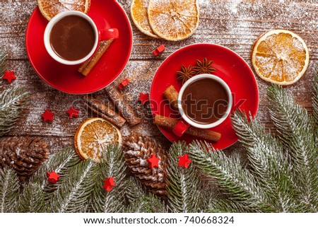 Christmas banner with green tree, red cup with hot chocolate and citrus slices on brown wooden background under imitative snow. Xmas and New Year congratulation card.