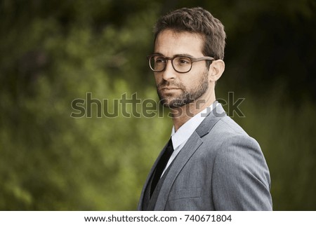 Businessman wearing glasses, deep in thought 