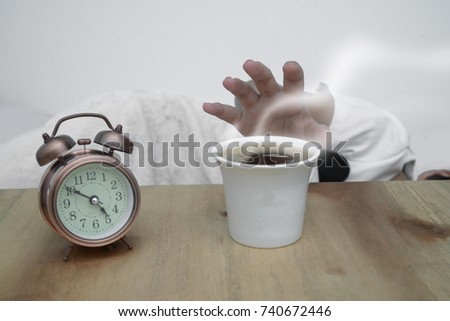 Alarm clock and coffee cup hot
on the table,
And a man sleep in the back.He reached for the glass handle.
Content to be drinking coffee when you wake up.