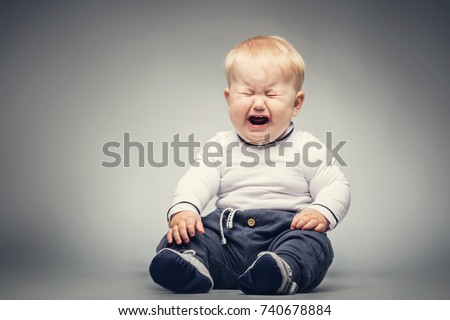Little baby boy sitting on the ground with crying face expression. Royalty-Free Stock Photo #740678884