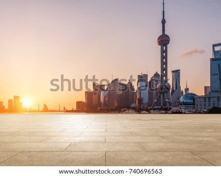 empty brick platform with Shanghai skyline in background at twilight.
