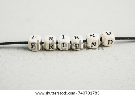 Beads word Friend.  A series of minimalistic conceptual compositions of beads on gray background. Words, phrases and expressions. Horizontal