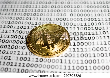 Gold bitcoin against the background of a binary system of zeros and ones