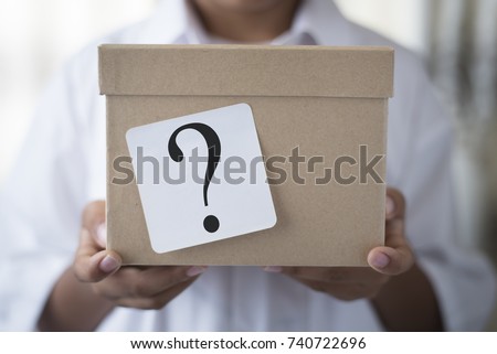young boy holding a box with white note question mark. whats in the box