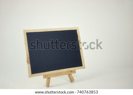 Vintage mood and tone of blank black board on wooden stand for price tag design space