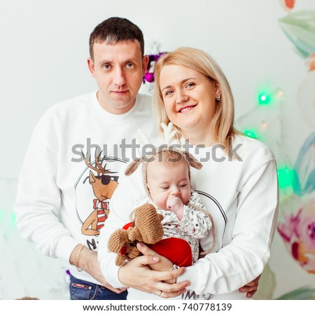 Mom and dad pose with their little son with deer ears