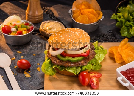 Fresh homemade Meat Burgers on dark slate stone board, over black stone background. Top view.