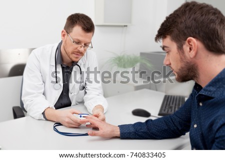 A doctor consulting oxygen saturation and heart rate with a pulse oximeter Royalty-Free Stock Photo #740833405