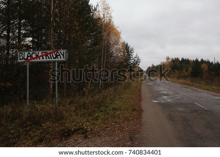 Black Friday is over Just Ahead white Road Sign with autumn road and gray sky