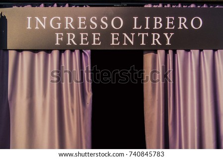 Exposure with free entry sign and purple curtains
