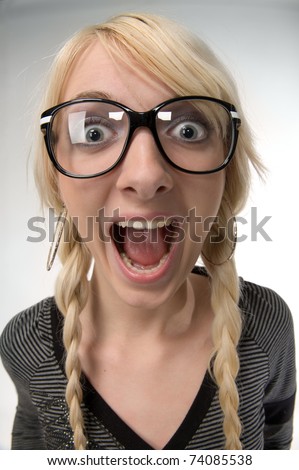 Happy and smart young blond woman with funny glasses and plait looks like nerdy girl. Smiling and looking at camera, humor style on white background.