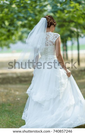
The bride in the wedding dress is standing with her back